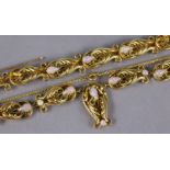 A gilt-metal flexible necklace & matching bracelet of lyre-shaped foliate links set simulated opals: