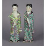A pair of late 19th century Chinese famille rose porcelain standing scholar figures, 10¾” high (each