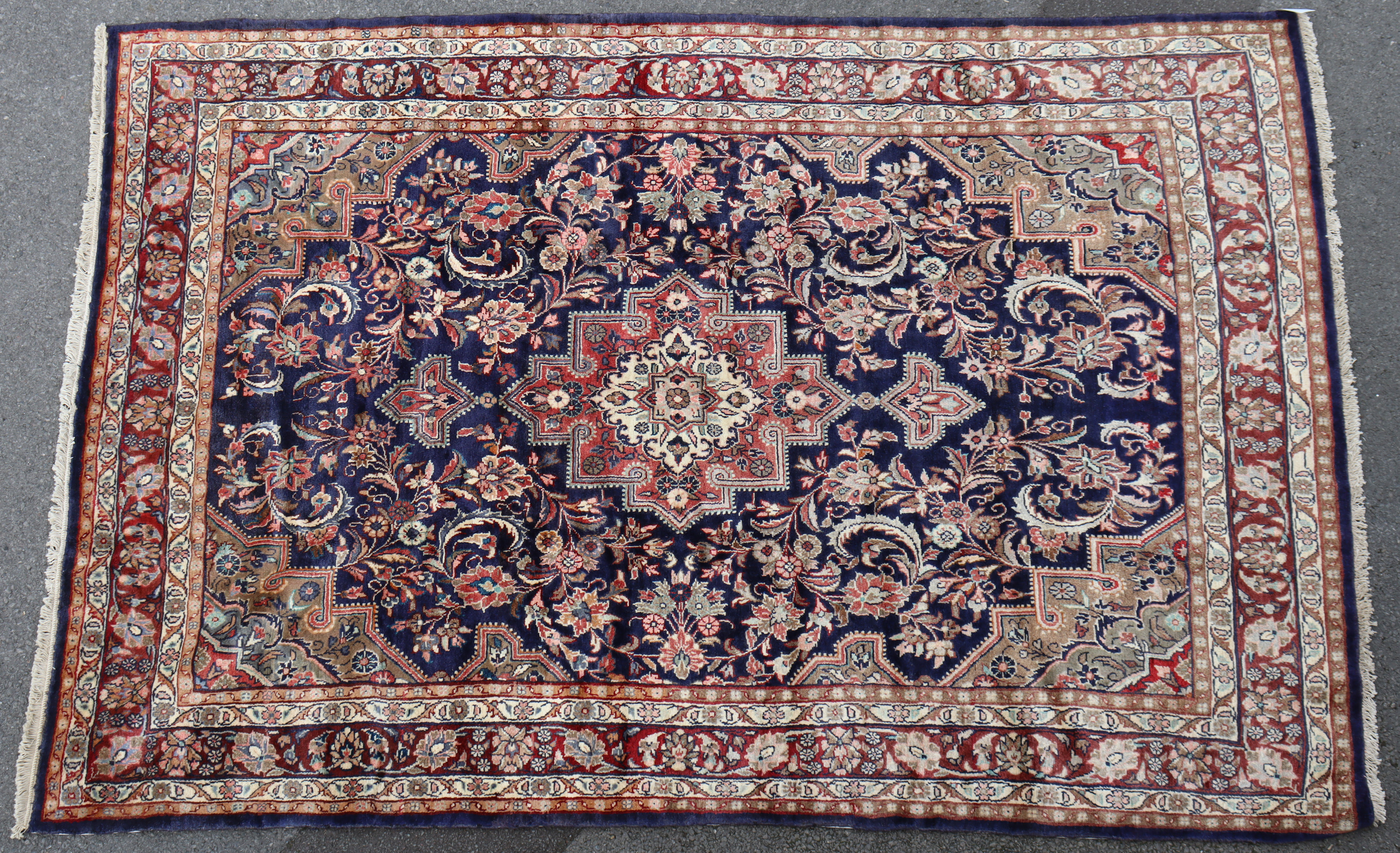 A North West Persian Hamadan rug of madder ground with geometric floral designs surrounded by narrow