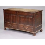 A late 18th century oak mule chest with hinged lift-lid, the fielded four-panel front above two