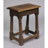 A 17th century oak joint stool with moulded edge to the hard seat, on turned tapered supports with