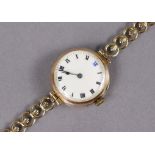 A 9ct. gold ladies’ wristwatch, the white enamel circular dial with black roman numerals & blue XII,