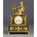 A 19th century French bronzed metal & ormolu mantel clock, in Empire style case, the 3¼” white enam