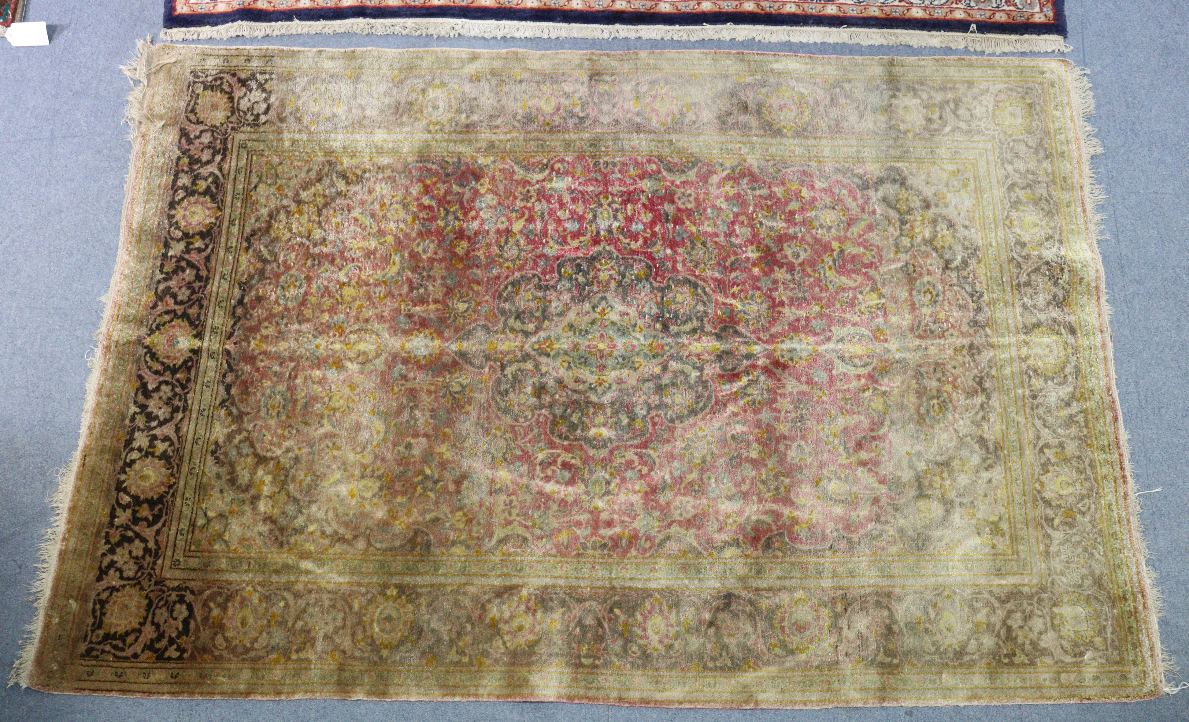 A Persian silk rug of crimson ground with central medallion in multiple foliate borders, 81" x 60".