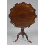 A Georgian mahogany tripod table with pie-crust edge to the circular tilt-top, on vase-turned column