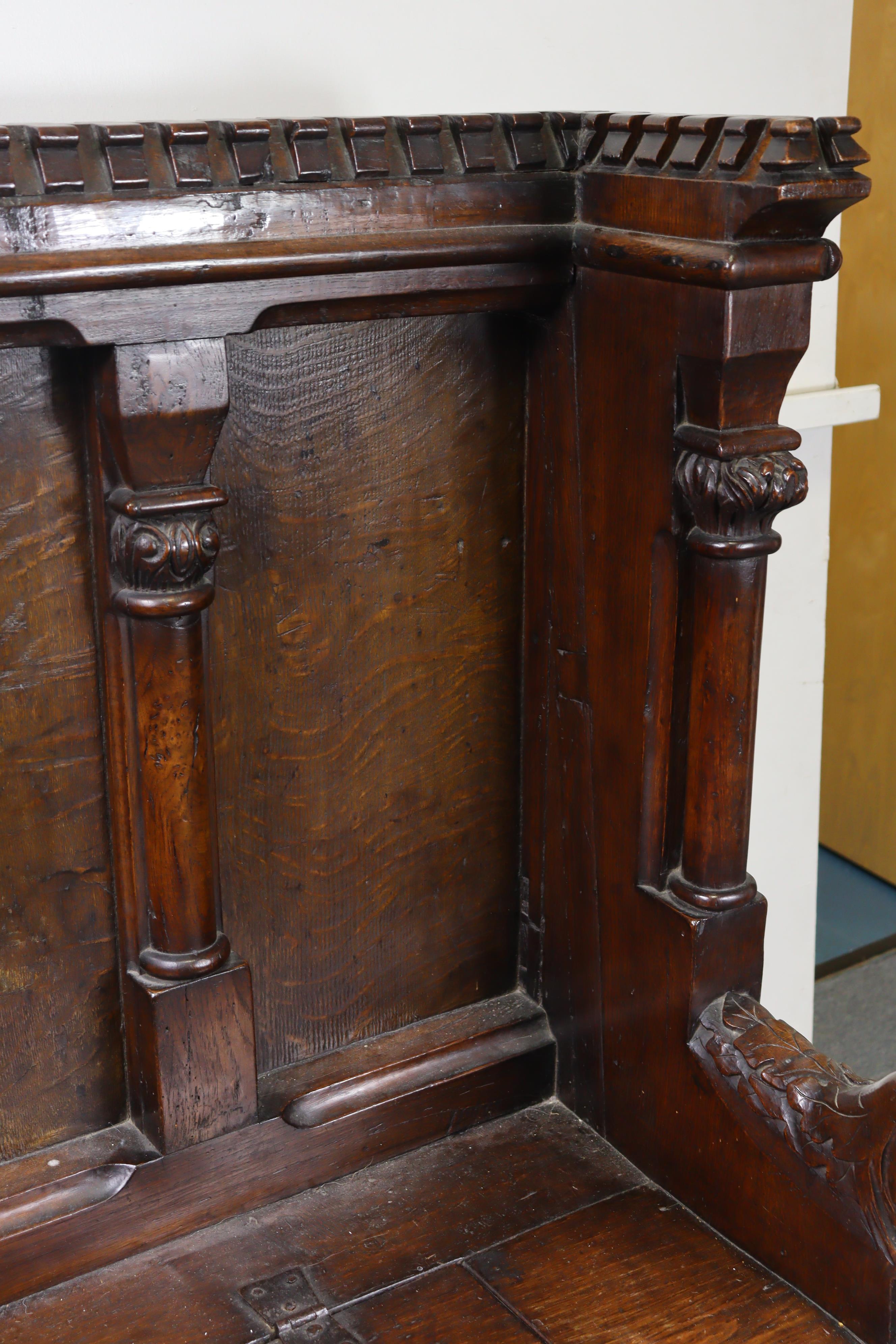 A late Victorian oak box-seat settle in the Gothic manner, the castellated panelled back flanked - Image 6 of 11