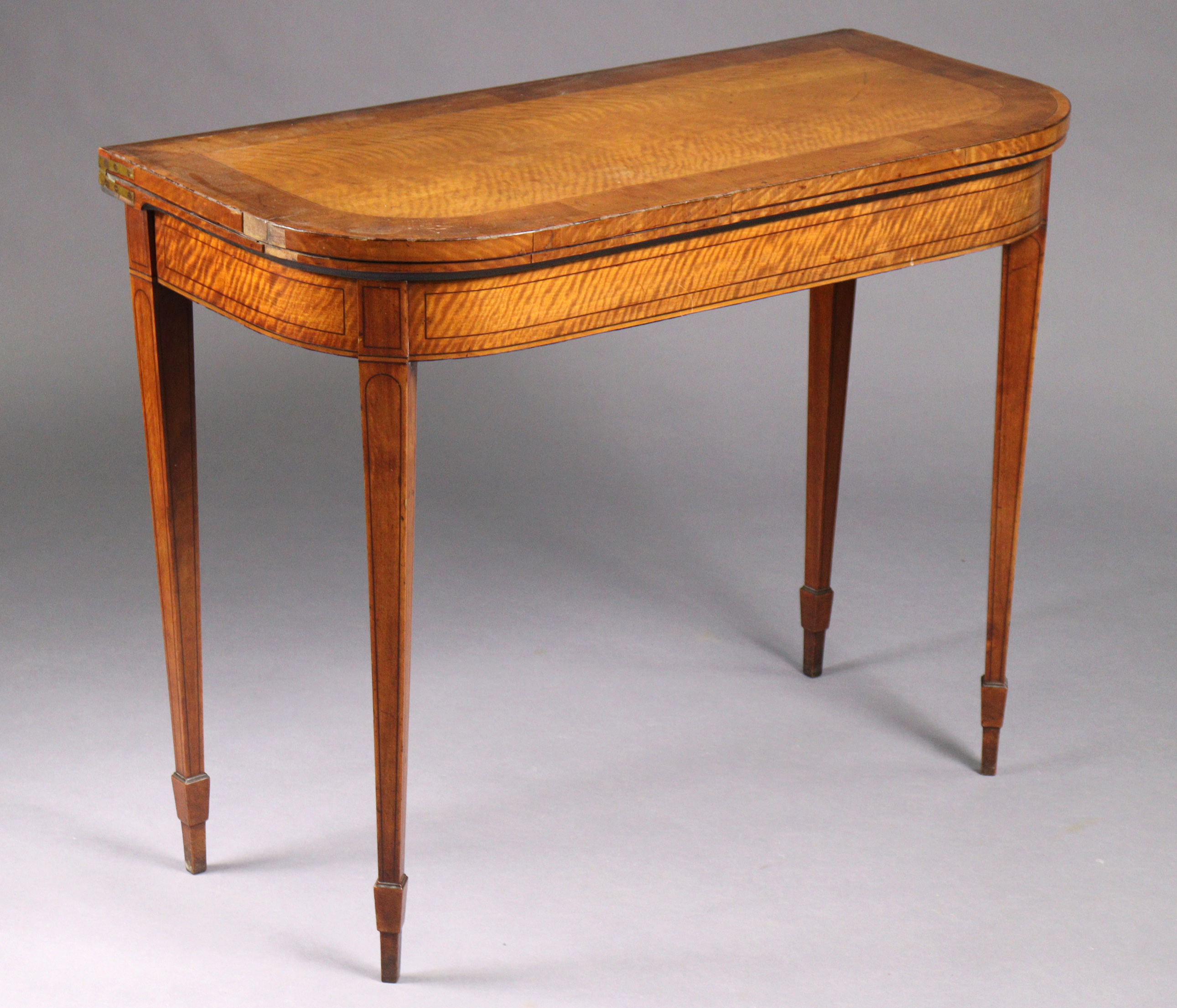 A George III inlaid satinwood card table with rounded corners to the rectangular fold-over top,