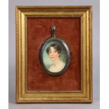 A 19th century portrait miniature of a lady, her dark brown hair in short curls, 2¼”x1¾”, in brass