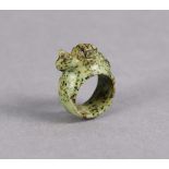 A mottled green hardstone finger ring with carved zoomorphic carving to the top, 1”x1½”. (hole 2cm