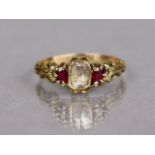 An antique gold ring set cushion-shaped old cut foil-backed diamond, a small ruby either side; size: