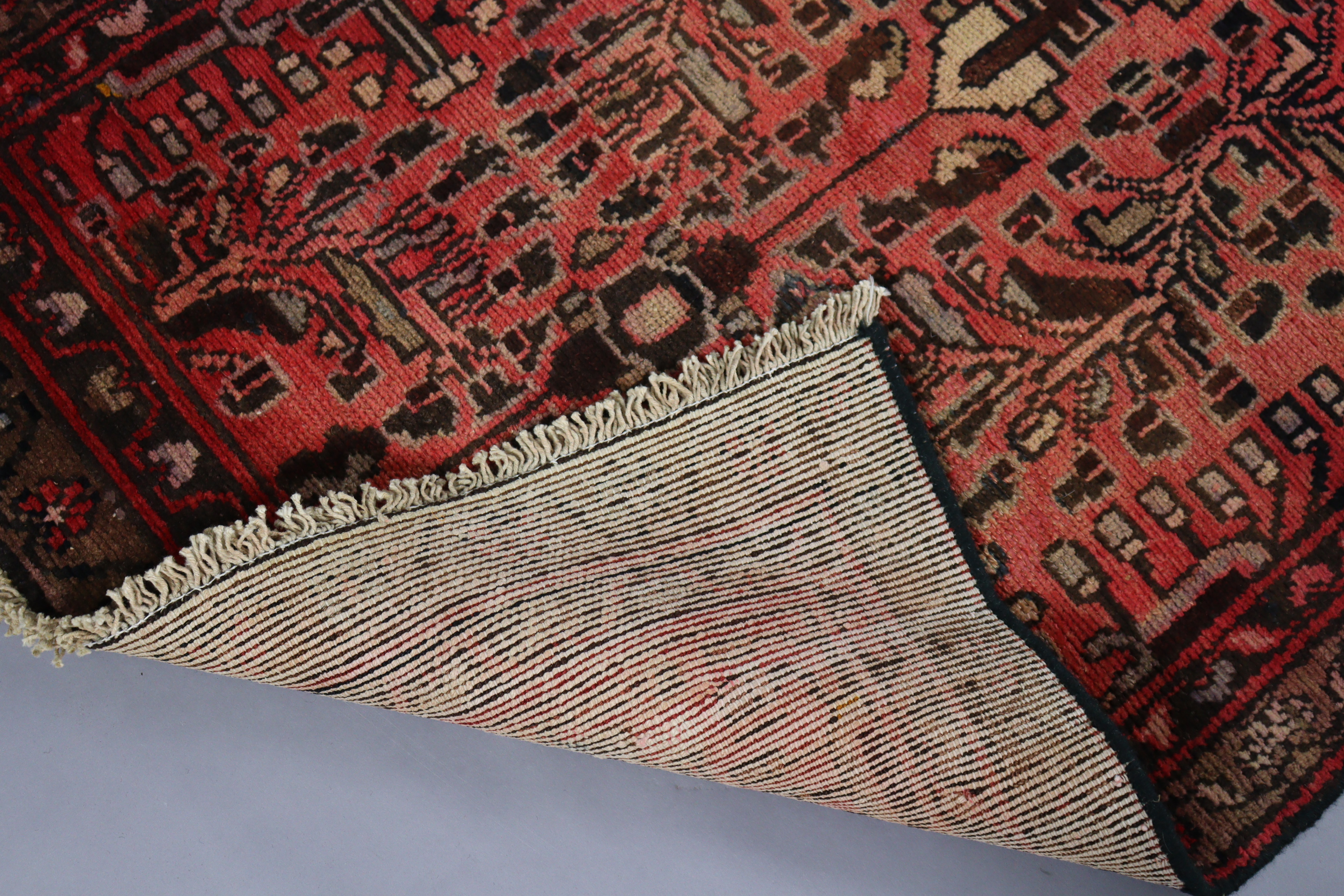 A Persian Zanjan rug of madder ground with repeating geometric designs surrounded by a wide - Image 2 of 2