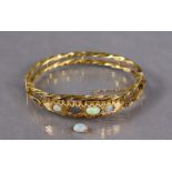 A 9ct. gold & opal stiff hinged bangle of open rope-twist design, set four graduated oval stones (