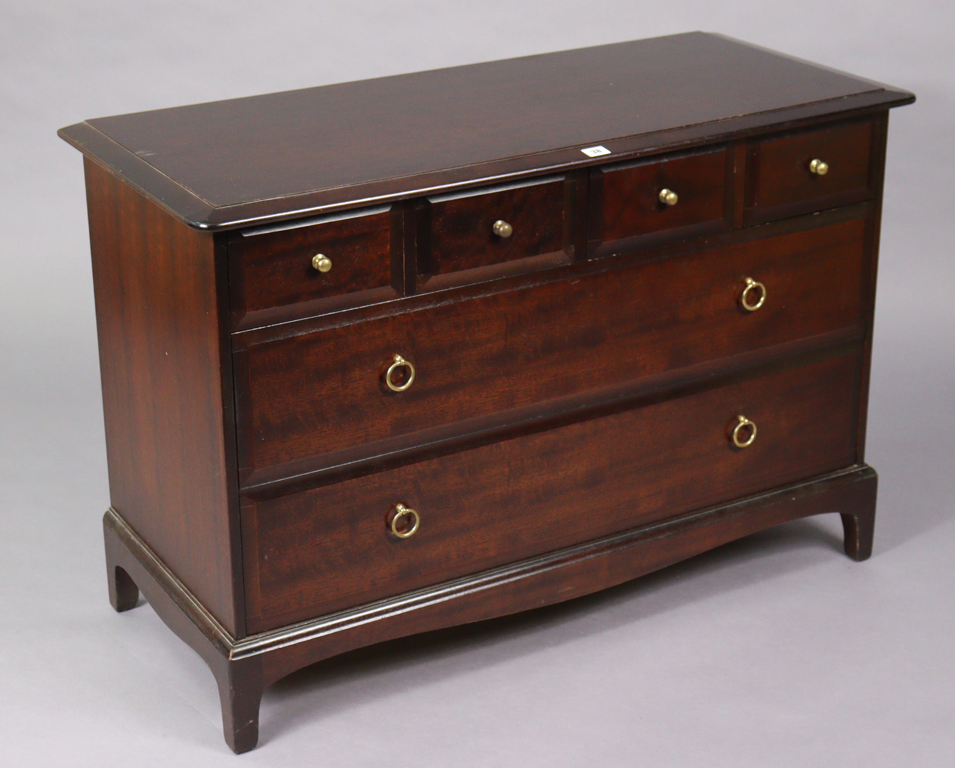 A Stag “minstrel” mahogany-finish dwarf chest fitted four short & two long drawers, & on a shaped