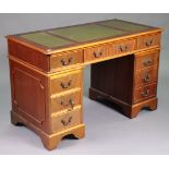 A reproduction mahogany pedestal desk inset gilt-tooled green leather, fitted three frieze