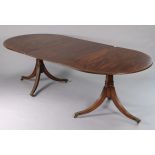 A regency-style inlaid-mahogany twin-pedestal tilt top extending dining table with d-shaped ends,