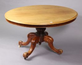 A Victorian mahogany pedestal dining table with a moulded edge to the oval tilt-top, & on a carved