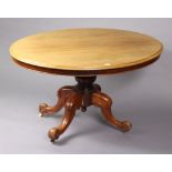 A Victorian mahogany pedestal dining table with a moulded edge to the oval tilt-top, & on a carved