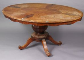 A Victorian walnut pedestal dining table with a moulded edge to the oval tilt-top, & on a vase