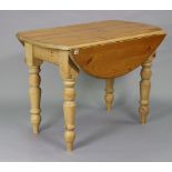 A pine oval drop-leaf kitchen table on four turned legs, 42” wide x 30” high.