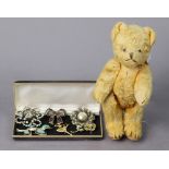 A small golden plush teddy bear with button eyes & movable limbs, 9” tall; & six various costume