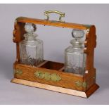 A Victorian oak & brass mounted tantalus, together with two cut-glass decanters.