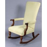 An early 20th century beech-frame rocking chair with padded seat, back & arms, & on turned