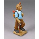 A vintage carved & painted wooden figure of Tin-tin, dressing in hiking gear holding a stick, on