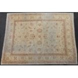 A Persian rug of camel ground with repeating floral designs, 143" x 107".