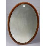 An Edwardian inlaid-mahogany frame oval wall mirror inset with a bevelled plate, 25¾” wide x 35¾”