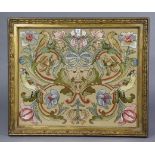 An embroidered panel depicting four birds amongst flowers, 24¼” x 29¼” in a glazed gilt frame.