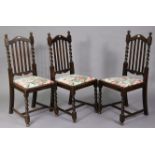 A set of three 1930’s oak rail-back dining chairs with padded drop-in-seats, & on barley-twist