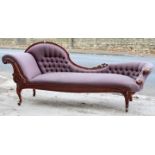 A Victorian chaise lounge with a buttoned shaped back, scroll end & sprung seat upholstered mauve