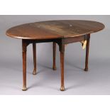 A 1930’s oak oval gate-leg dining table on cabriole legs and pad feet, 35¼” wide x 28” high.