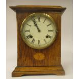 An early 20thC oak cased mantel clock with a marquetry motif, a platform top, straight sides and a