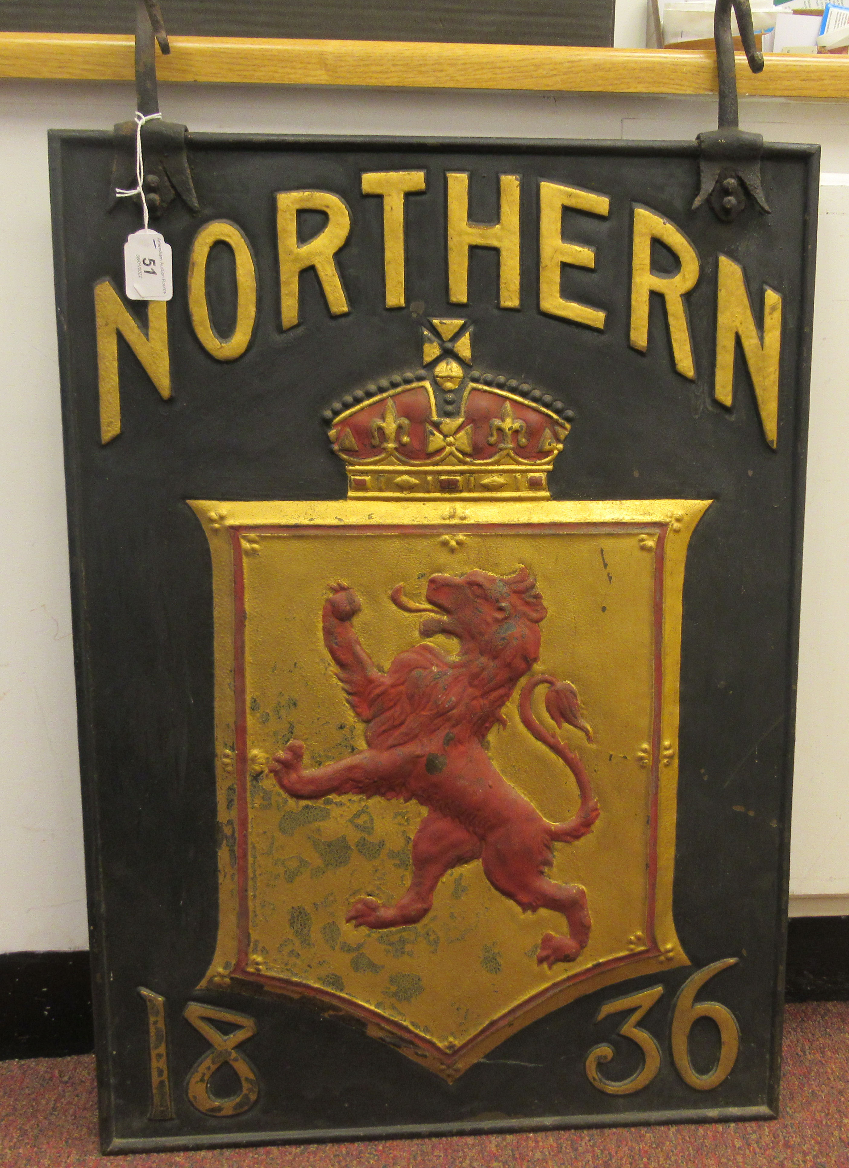 A 19thC black, red and gilt painted cast iron external hanging  advertising sign, featuring a lion