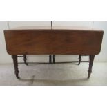 An early Victorian mahogany Pembroke table, raised on ring turned legs  28"h  47"L open