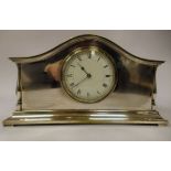 A 1930s elecroplated brass mantel timepiece with a low arched case and spindled baluster flank