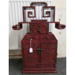 A 19thC Chinese cinnabar table cabinet with a scholar's cap superstructure, on a Ming style base,