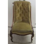 A late Victorian rosewood showwood framed nursing chair, the part buttoned, old gold coloured fabric