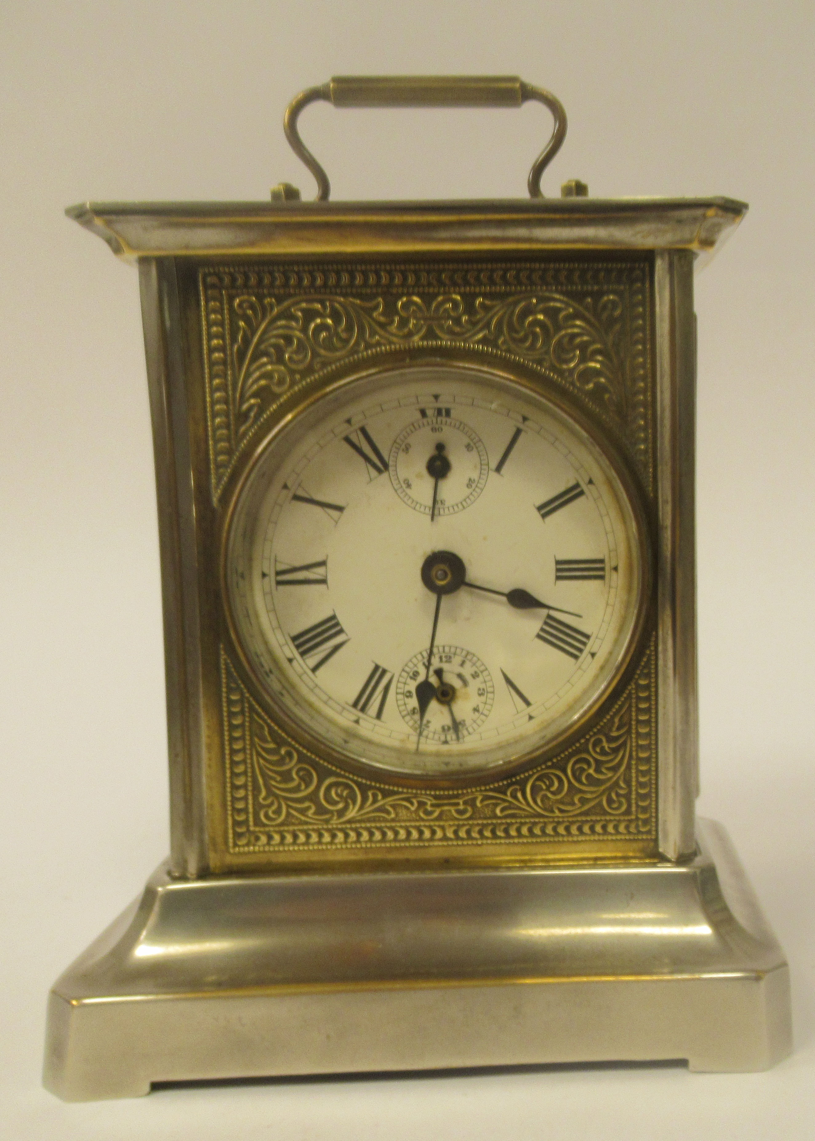 An early 20thC electroplated and brass inlaid mantel clock with a glazed panel and a folding top