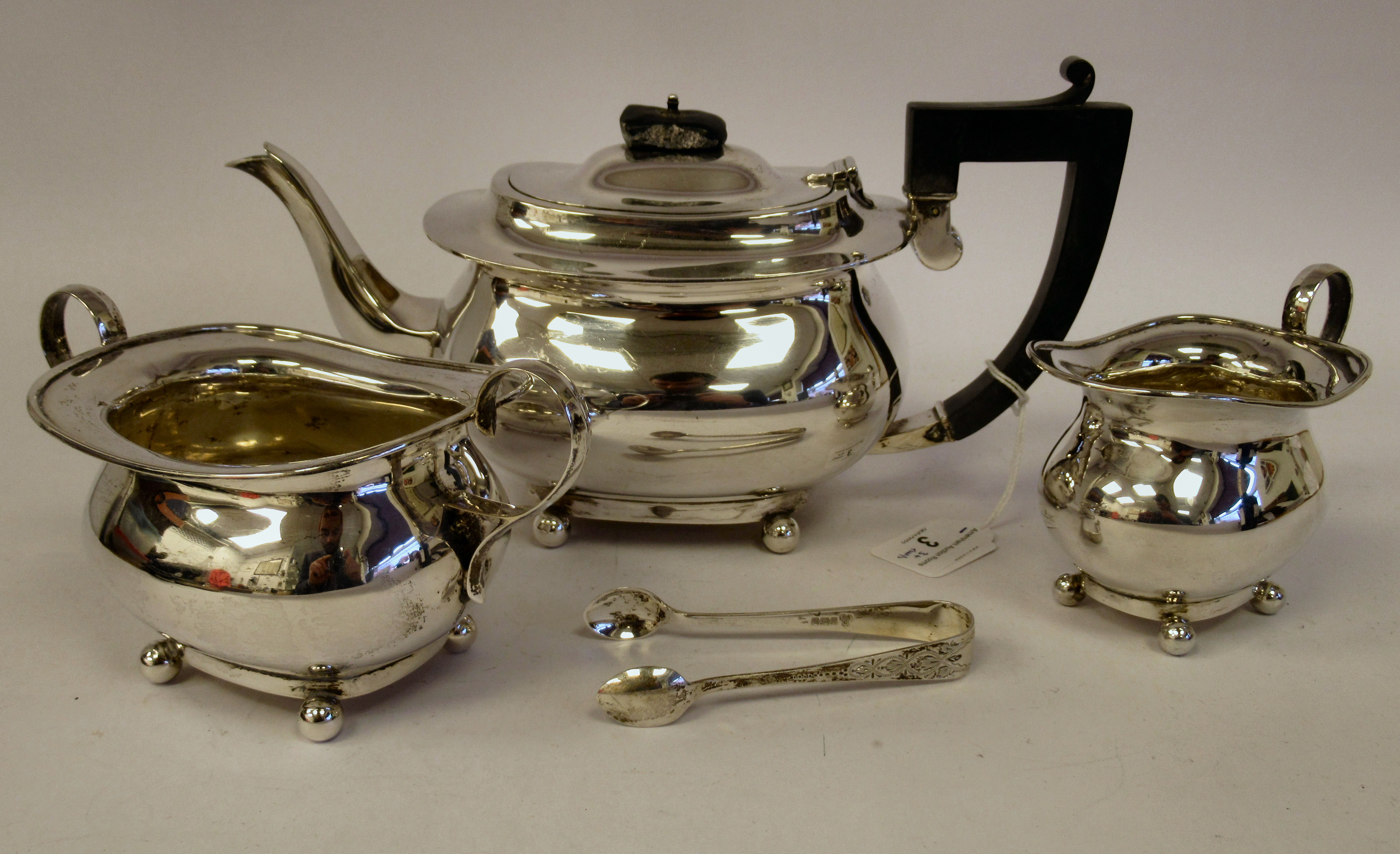 A three piece silver tea set of oval bulbous form, comprising a teapot with an S-shape spout,