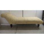 A late 19th/early 20thC chaise longue, upholstered in Art Nouveau patterned fabric, raised on turned