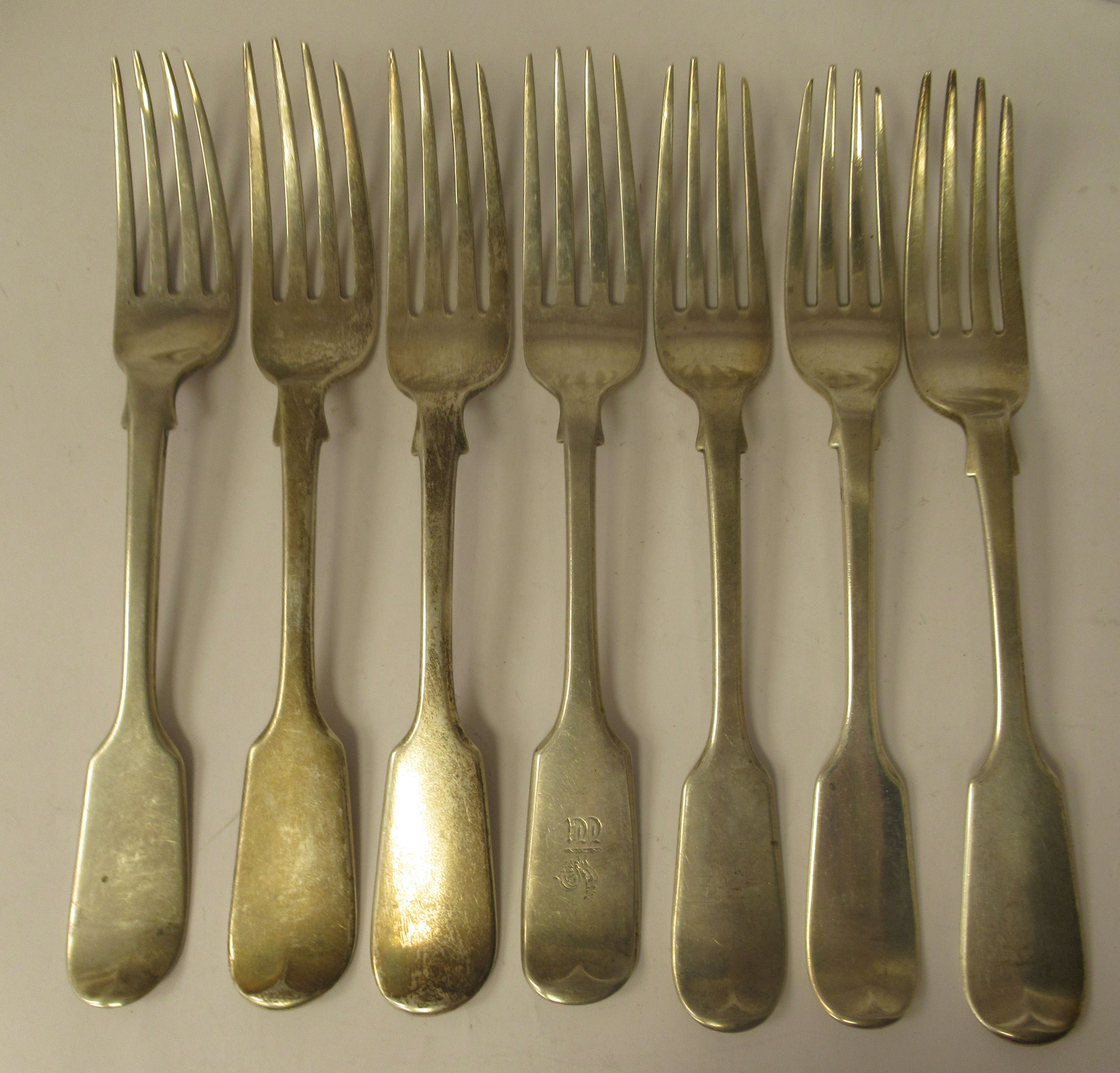 A matched set of seven 19thC silver fiddle pattern table forks  mixed marks