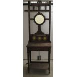 An Edwardian mahogany framed hallstand with a tiled upstand, hooks and a mirror, over a single