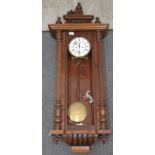 A late 19th/20thC Gustav Becker walnut cased wall clock with a traditionally styled cornice, flank