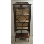 An Edwardian string inlaid mahogany display cabinet with a glazed door, enclosing three shelves,