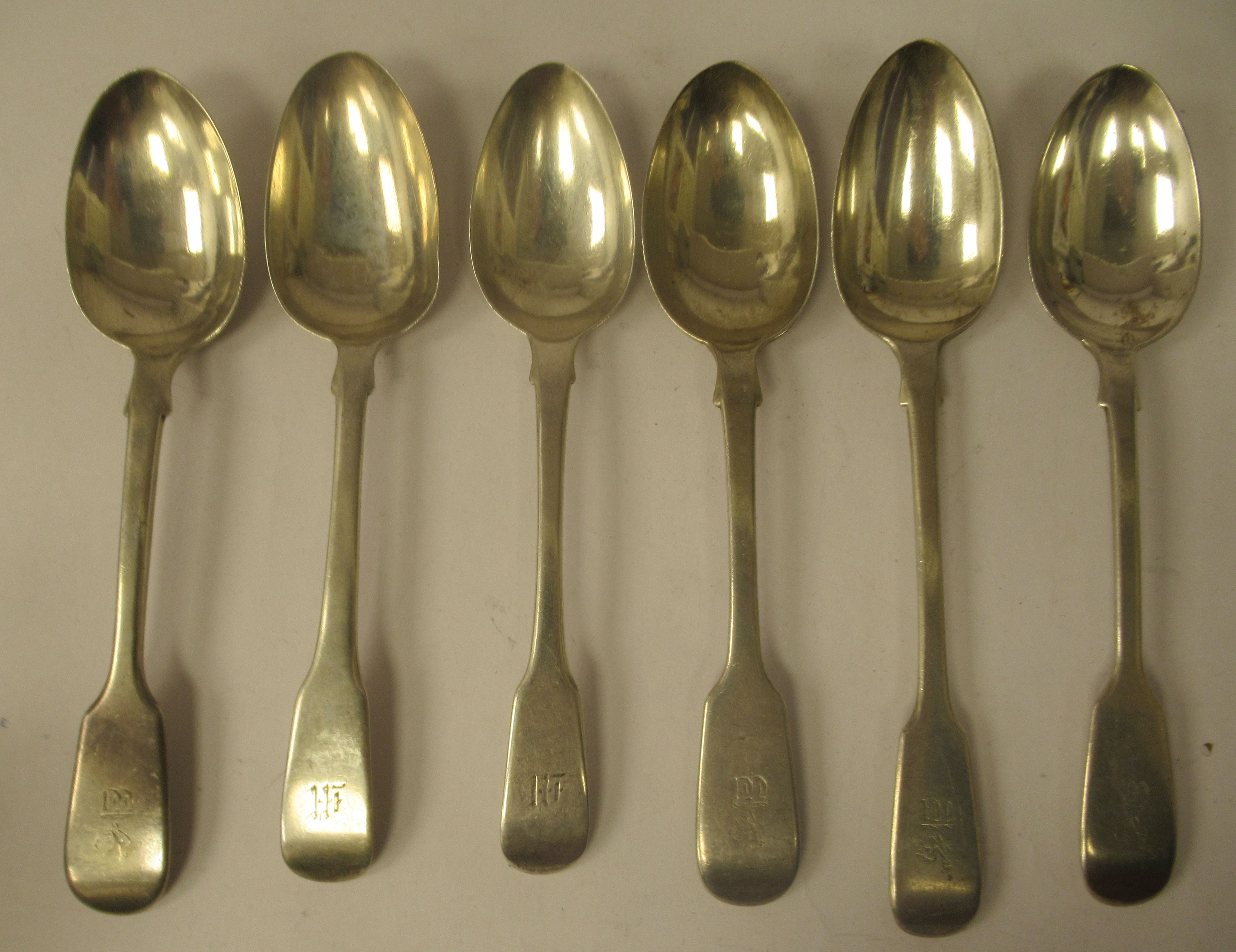 A matched set of six 19thC silver fiddle pattern dessert spoons  mixed marks