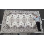 An Aztec pattern woollen carpet decorated with quadruple pole medallions, animal motifs and flora,