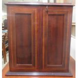 An Edwardian crossbanded mahogany smokers compendium with a pair of doors, enclosing a part fitted