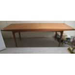 A 1960s/70s Gordon Russell teak coffee table, raised on square, tapered legs  16"h  48"w